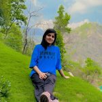 Leena Chaudhary relaxing on grass during her trekking trip
